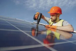 A technician installing a solar panel on rooftop